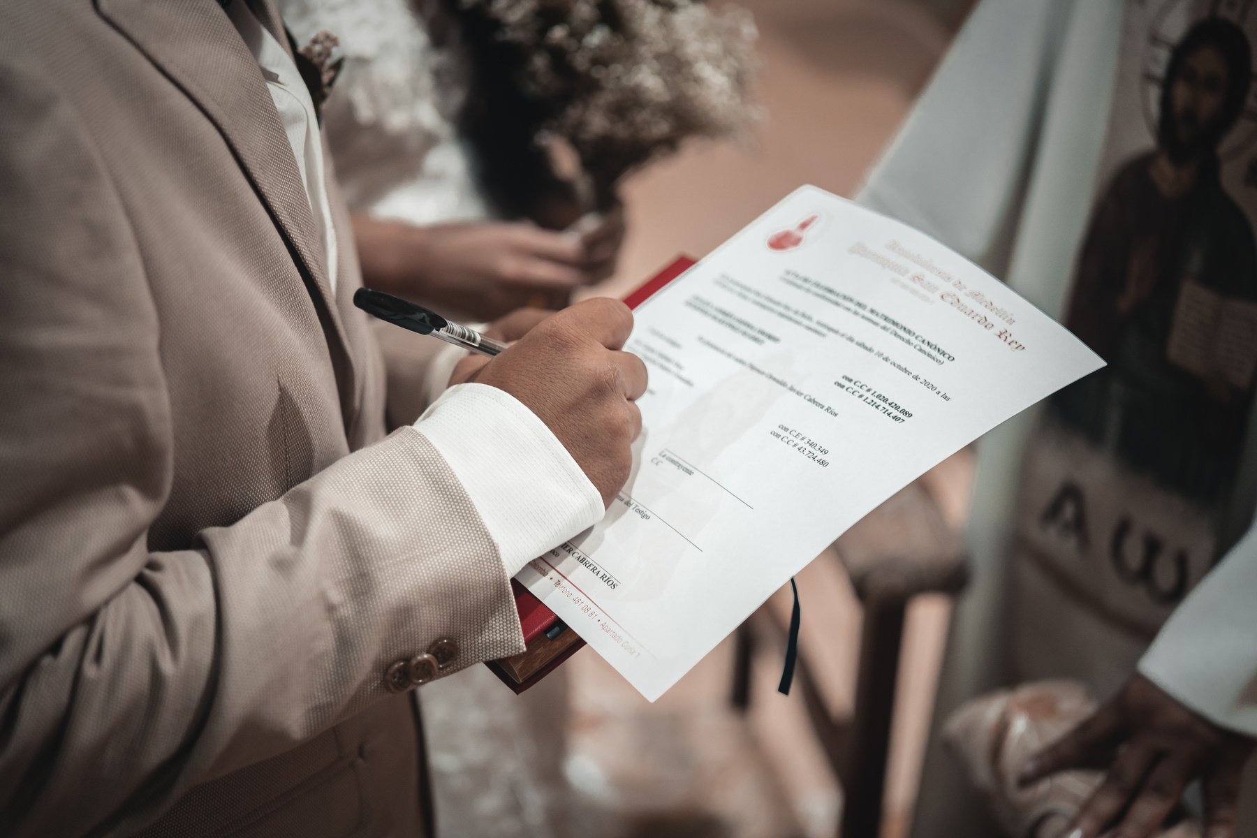 Crop unrecognizable groom signing documents during wedding ceremony